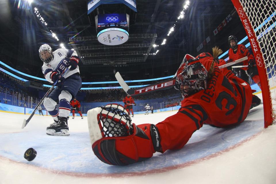 The puck skids past Canadian goalkeeper Ann-Renee Desbiens as United States' Hilary Knight scores