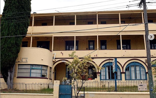 The Oslo Hotel's blue and yellow facade in St Kilda taken from the street