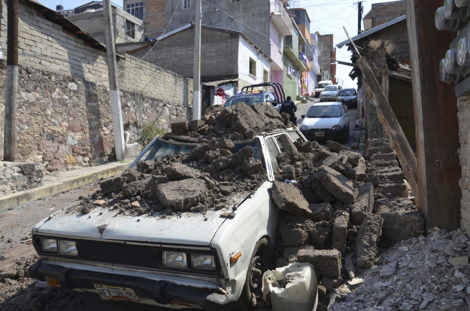 Un auto estacionado sufrió daños cuando una pared de adobe se desplomó en el fuerte terremoto de magnitud 7,2 que afectó Chilpancingo, México, la mañana del viernes 18 de abril de 2014. (Foto AP/Alejandrino González)