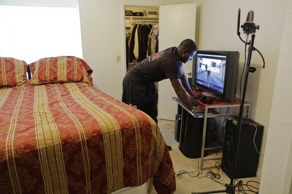 Sgt. Leo Dunson pulls up one of his rap music videos at his apartment,Thursday, April 26, 2012, in Las Vegas. While working to earn a degree in political science, Dunson focuses much of his engergy on building a career in rap with music that focuses on his journey serving in Iraq with the Army and his battle with PTSD. (AP Photo/Julie Jacobson)