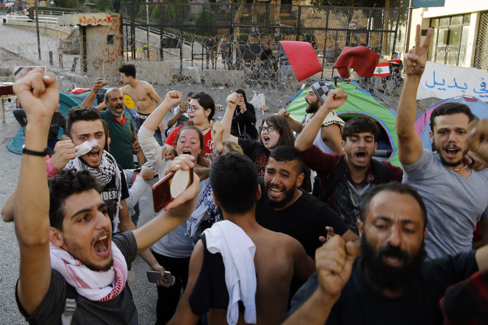 Anti-government protesters celebrate after Lebanon Prime Minister Saad Hariri announced he is submitting his resignation, meeting one of their main demands, in front of the government palace in Beirut, Lebanon, Tuesday, Oct. 29, 2019. The protests have been on the streets for 13 days, calling for the government to resign and accusing longtime politicians of corruption. (AP Photo/Bilal Hussein)