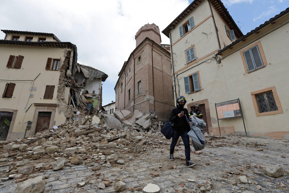 A resident passes in front of the collapsed bell tower