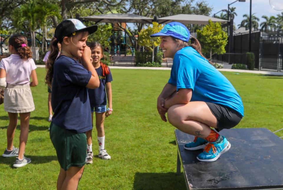 Palm Beach Public School student Anna Sue Roads, 8, talks with Energy Cubes Challenge team member Clemence Chateauvert at the Mandel Recreation Center athletic field before participating in a Zumba fitness class on Monday.