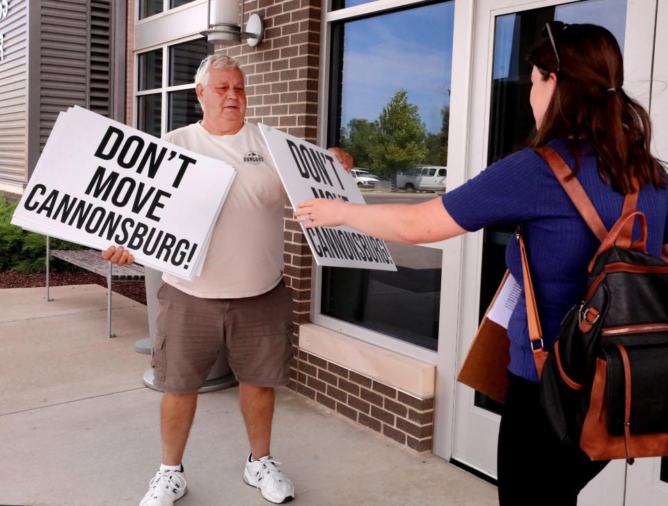 Jerry Gammon hands out a sign to not move Cannonsburgh tVillage o Heather Cadenhead, who spoke to save the Village during the public comment section in front of the Murfreesboro City Council on Thursday, Sept. 14, 2023, where a new minor league AA baseball stadium and team coming to Murfreesboro was discussed.