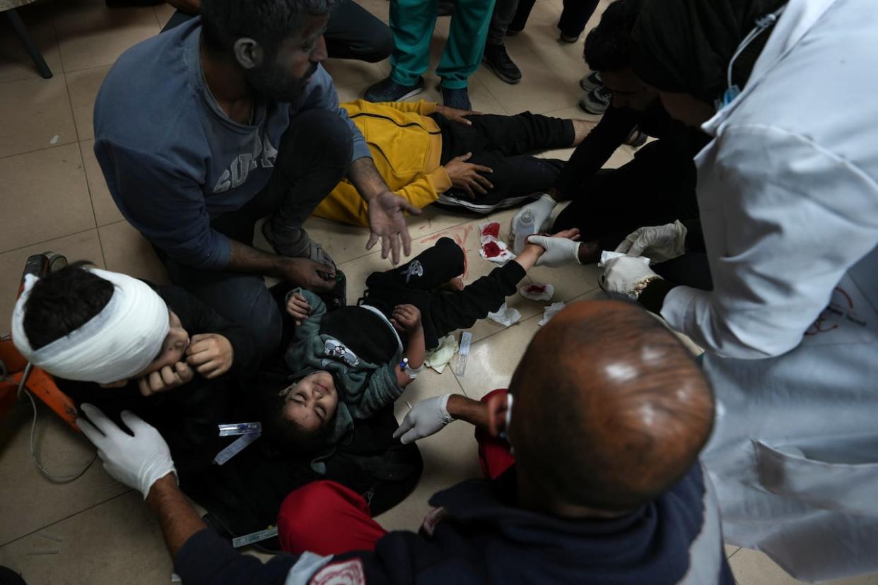 Palestinians wounded in the Israeli bombardment of the Gaza Strip are brought to the hospital in Deir al Balah on Friday, Dec. 8, 2023. (Adel Hana/Associated Press - image credit)