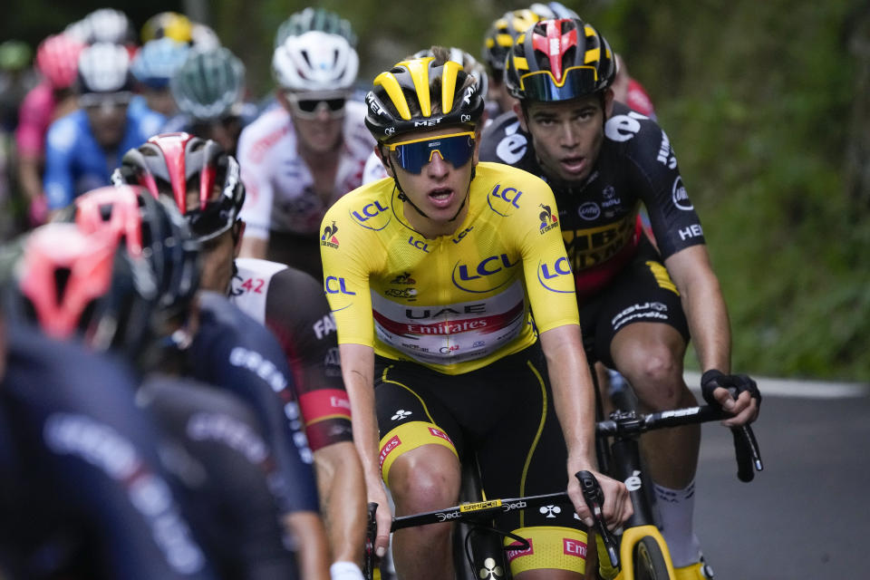 Slovenia's Tadej Pogacar, wearing the overall leader's yellow jersey, and Belgium's Wout Van Aert, right, climb during the eighteenth stage of the Tour de France cycling race over 129.7 kilometers (80.6 miles) with start in Pau and finish in Luz Ardiden, France,Thursday, July 15, 2021. (AP Photo/Christophe Ena)