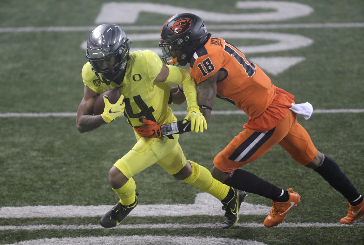 Oregon's Kris Hutson (14) tries to get past Oregon State cornerback Alex Austin during the second quarter of last year's game at Reser Stadium in Corvallis.
