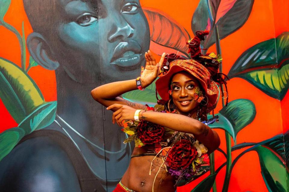 Queens resident and festivalgoer Jasmine NIchole, 29, poses in front of the artwork of her friend, Terrea Armsting, 24, during AFROPUNK music festival at The Urban in the Historic Overtown neighborhood of Miami, Florida, on Saturday, May 21, 2022.