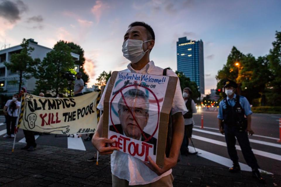 A protester holds a placard with a picture of Thomas Bach during a demonstration against the Games, earlier this week.