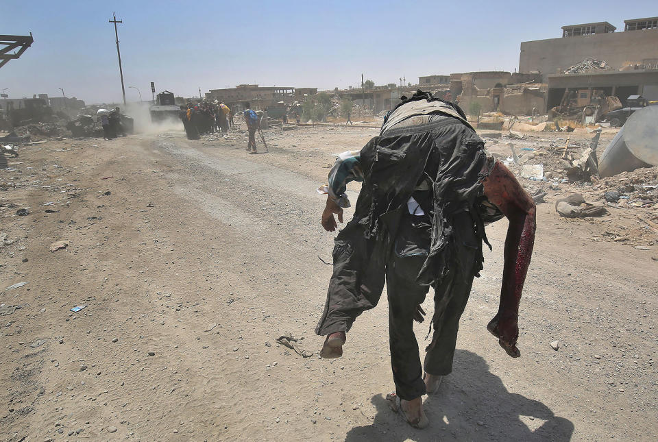 <p>An Iraqi carries a wounded man while fleeing from the Old City of Mosul as Iraqi forces advance on June 20, 2017, during the ongoing offensive to retake the last district still held by the Islamic State (IS) group. (Photo: Ahmad al-Rubaye/AFP/Getty Images) </p>