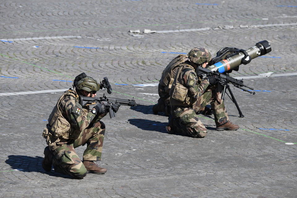 <p>Members of the Section Technique de l’Armee de Terre (Technical Section of the Army) hold German HK 416 assault rifles as they kneel beside an anti-tank missile during the annual Bastille Day military parade on the Champs-Elysees avenue in Paris on July 14, 2017. (Photo: Alain Jocard/AFP/Getty Images) </p>