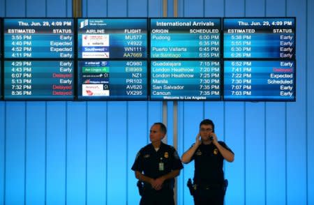 FILE PHOTO - U.S. Customs and Immigration officers keep watch at the arrivals level at Los Angeles International Airport in Los Angeles, California, U.S., June 29, 2017.  REUTERS/Mike Blake