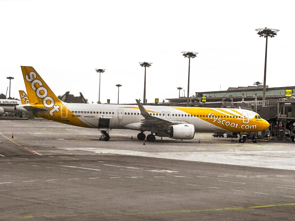 A yellow-and-white aircraft at an airport.