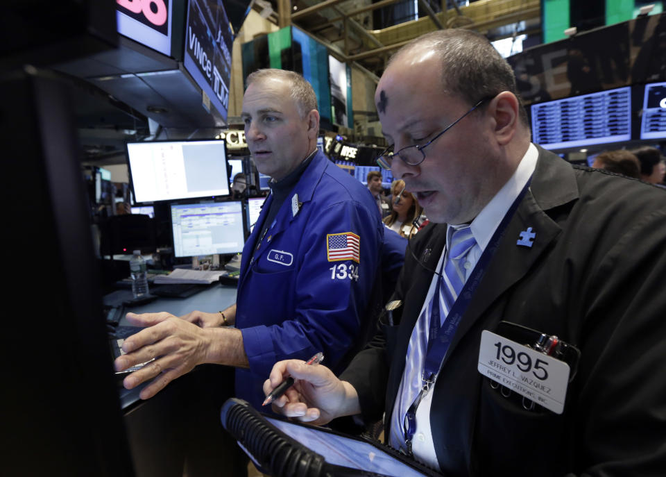 Trader Jeffrey Vazquez, right, works on the floor of the New York Stock Exchange, Wednesday, March 5, 2014. Stocks are little changed in early trading, a day after setting a record high, as traders were unimpressed by a slight increase in hiring at private companies last month.(AP Photo/Richard Drew)