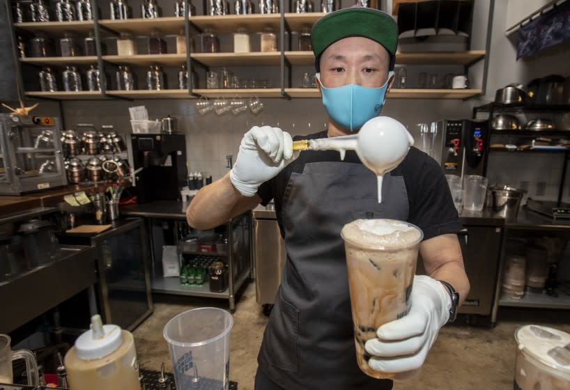 LOS ANGELES, CA - APRIL 14: Hey Hey Contemporary Tea House & Common Room owner Chris Kwok puts the finishing touches on the "Hey Hey" a refreshing boba beverage on Wednesday, April 14, 2021 in Los Angeles, CA. (Brian van der Brug / Los Angeles Times)