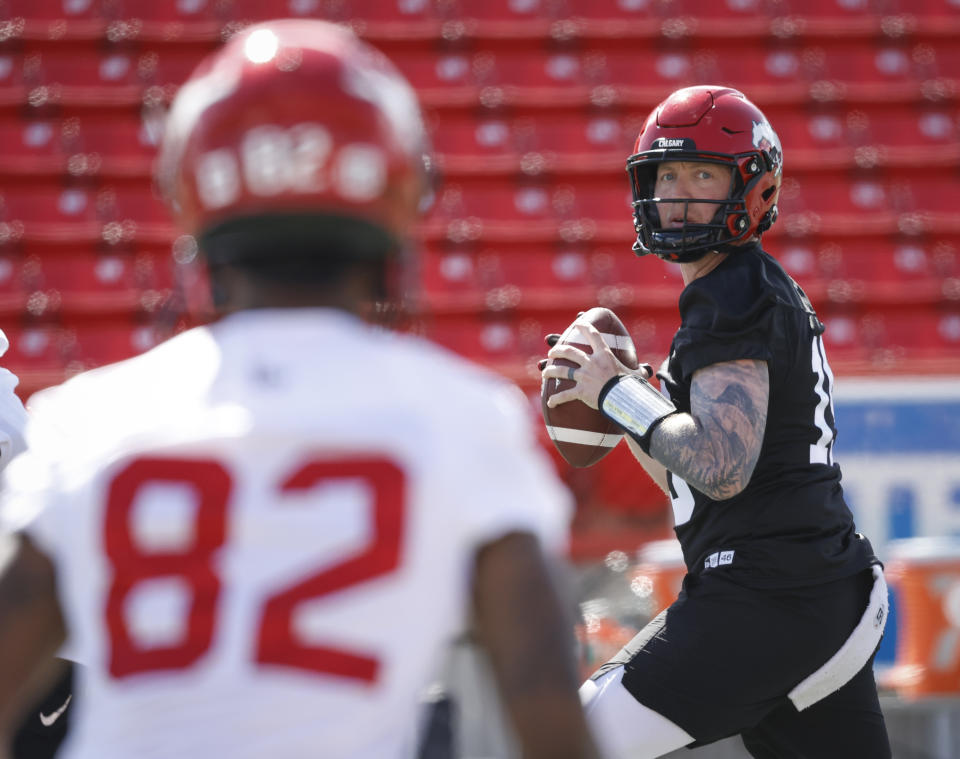 Calgary Stampeders quarterback Bo Levi Mitchell, right, looks to Malik Henry during opening day of the Canadian Football League team's training camp in Calgary, Alberta, Sunday, May 15, 2022. (Jeff McIntosh/The Canadian Press via AP)