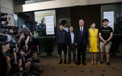 Five democracy activists are photographed by the media outside a Hong Kong court on Wednesday, following their sentencing - Credit: Justin Chin/Bloomberg