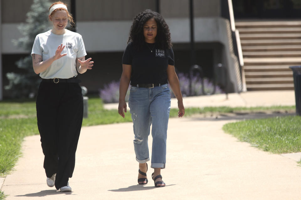 Kansas voting rights activists Chloe Chaffin, left, and Anita Alexander, talk while walking on the Washburn University campus, Friday, May 18, 2024, in Topeka, Kan. Their group, Loud Light, does voter registration drives on college campuses but has suspended that work while it challenges a state elections law that it says hampers registration drives. Laws passed in several Republican-controlled states are making it challenging for advocates to adapt as they try to register and educate potential voters with just months to go before the presidential election. (AP Photo/John Hanna)