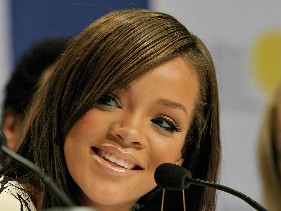 Rihanna speaks into a microphone at a news conference in 2006