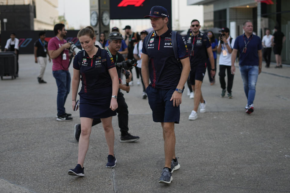 Red Bull driver Max Verstappen of the Netherlands, right, walks through the paddock at the Lusail International Circuit, Lusail, Qatar, Thursday, Oct. 5, 2023. The Qatar Formula One Grand Prix race will be held on Sunday. (AP Photo/Ariel Schalit)
