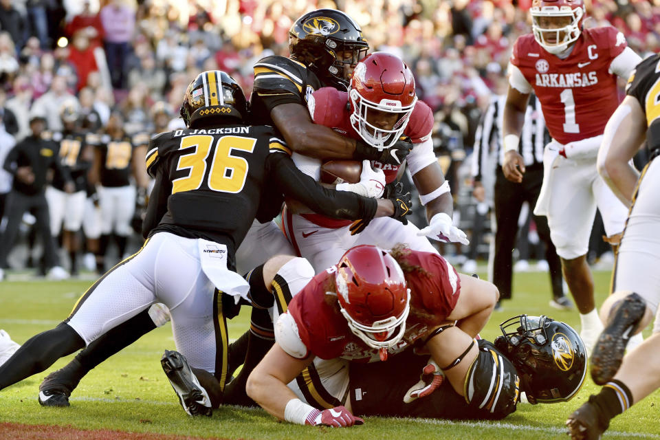 Arkansas running back Raheim Sanders (5) pushes past Missouri defenders DJ Jackson (36) and Chad Bailey (33) to score a touchdown during the first half of an NCAA college football game Friday, Nov. 26, 2021, in Fayetteville, Ark. (AP Photo/Michael Woods)