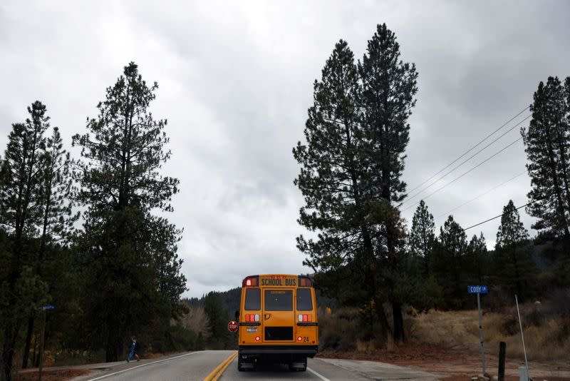 FILE PHOTO: A boy walks off a school bus, amid the coronavirus disease (COVID-19) pandemic, down a driveway outside Idaho Falls