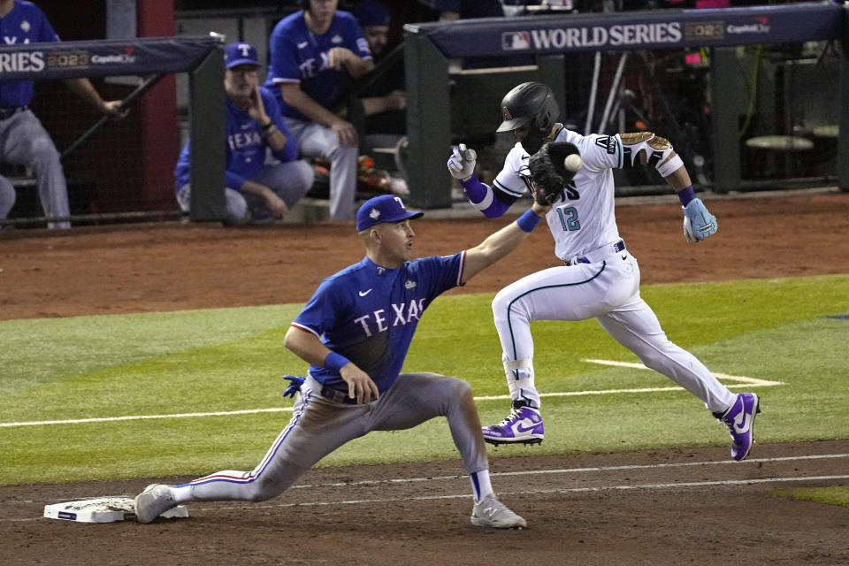 Arizona Diamondbacks' Lourdes Gurriel Jr. (12) is out at first as Texas Rangers first baseman Nathaniel Lowe catches the throw during the sixth inning in Game 3 of the baseball World Series Monday, Oct. 30, 2023, in Phoenix. (AP Photo/Ross D. Franklin)