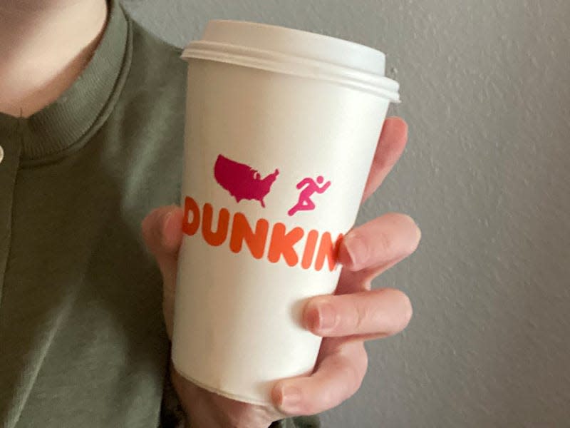 paige bennett holding a cup of dunkin chai latte