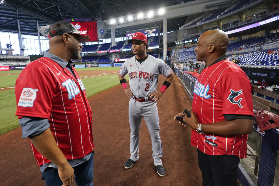 Cincinnati Reds shortstop Jose Barrero (2) chats with former pitchers Livan Hernandez, left, and his half-brother Orlando " El Duque" Hernandez, right, before the start of a baseball game between the Miami Marlins and the Reds, Saturday, May 13, 2023, in Miami. (AP Photo/Wilfredo Lee)