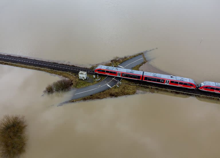 Un tren pasa por un cruce de ferrocarril que está rodeado por las inundaciones causadas por la lluvia y la nieve derretida en Nidderau, cerca de Frankfurt, Alemania, el 3 de febrero 