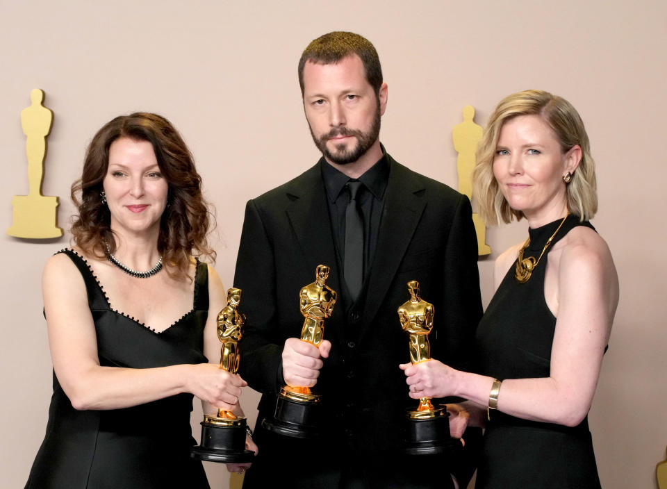 (L-R) Producer Raney Aronson-Rath, director Mstyslav Chernov, and producer Michelle Mizner in the press room of the Academy Awards.