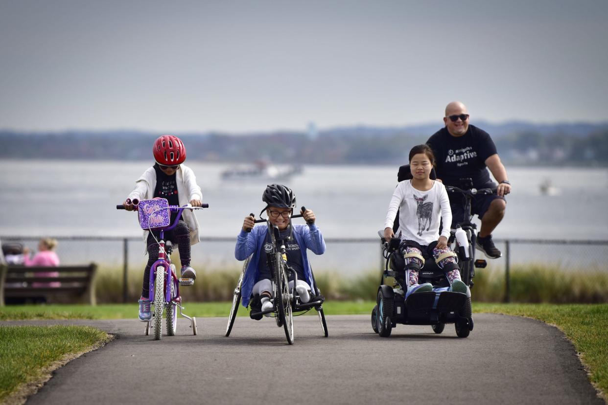(L to R), Sisters Yiman, Mia and Sofia Emory, who have physical disabilities, enjoy a family bike ride with their father, Pete Emory, at Raritan Bay Waterfront Park in South Amboy on Oct. 16, 2022.