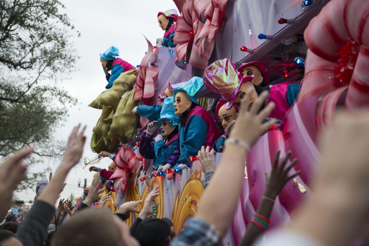 New Orleans, Louisiana, USA - February 9, 2013: Costumed men on a float throw beads into the crowd during a Mardi Gras parade (Krewe of Endymion) on Canal Street in New Orleans, Louisiana