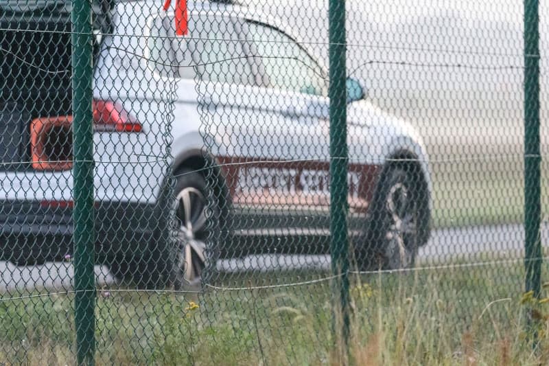 A Berlin-Brandenburg BER airport security car is parked behind the airport fence. The police assume that activists from the Last Generation Climate Initiative have gained access to the airport grounds through the visible hole in the fence. Julius Schreiner/dpa