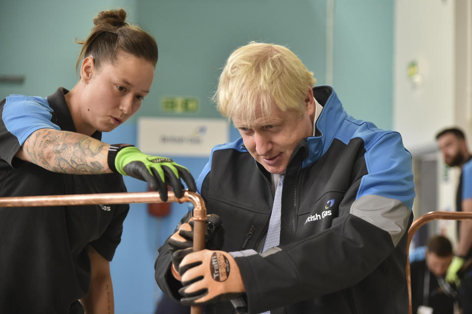 Britain's Prime Minister Boris Johnson listens to apprentice Amy Gray during a visit to a British Gas training academy in Leicestershire, England, Monday, Sept. 13, 2021.(AP Photo/Rui Vieira, Pool)