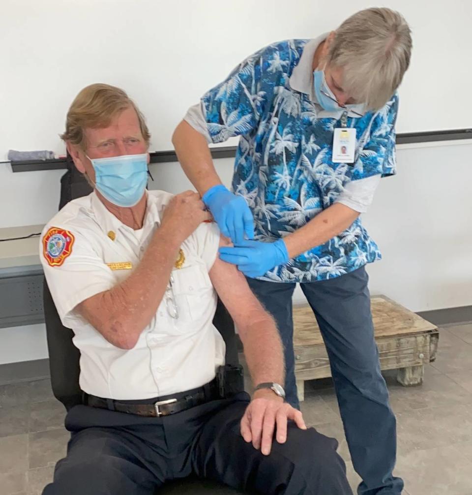 The Florida State Department of Health’s Amy Grimm vaccinates Monroe County Fire Rescue Chief Jim Callahan.