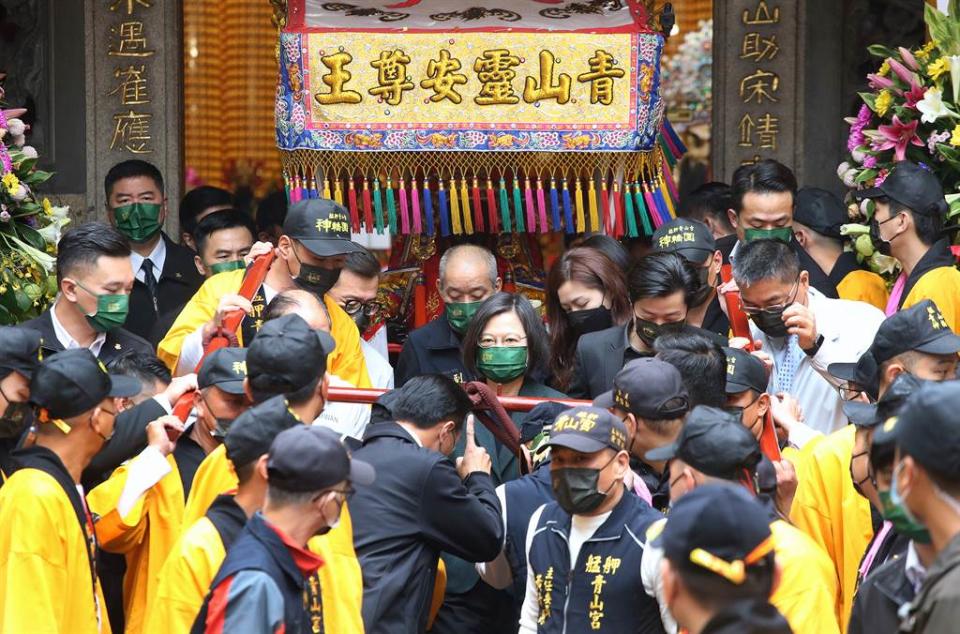 蔡英文總統（中）26日出席「艋舺青山王祭起駕儀式」，在眾人簇擁下扶著鑾轎緩緩走出廟門。（范揚光攝）