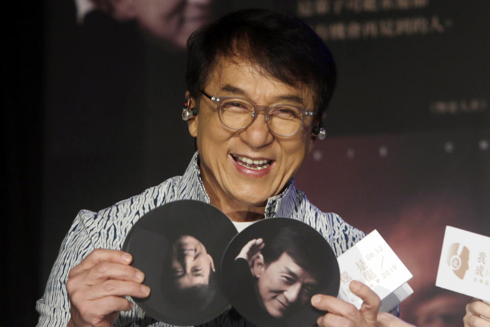 FILE - In this June 12, 2019, file photo, Hong Kong actor and singer Jackie Chan shows photos during a promotional event announcing his new album "I AM ME" in Taipei, Taiwan. A visit by Chan to Vietnam has been cancelled following complaints over his alleged pro-China stance on South China Sea sovereignty issues. (AP Photo/Chiang Ying-ying, File)