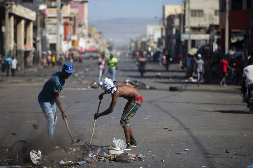 Residents clear a street so they can play soccer in a street devoid of cars due to a countrywide strike demanding the resignation of Haitian President Jovenel Moise in Port-au-Prince, Haiti, Monday, Feb. 1, 2021. (AP Photo/ Dieu Nalio Chery)