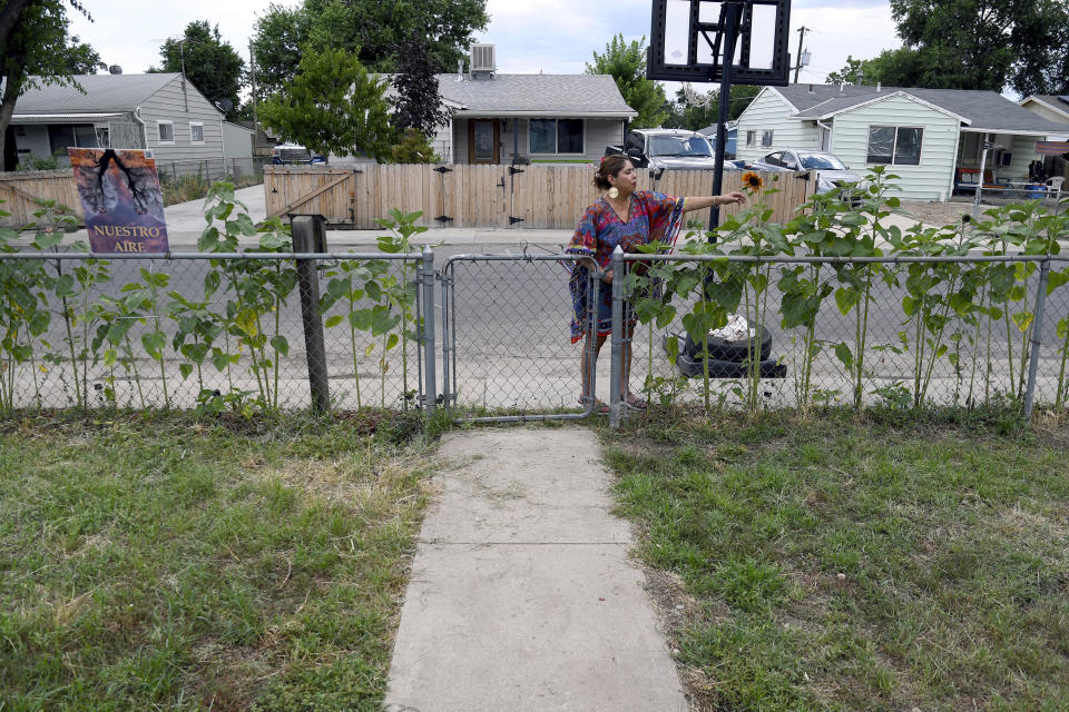 Lucy Molina tends to her garden in Commerce City, Colo., on Tuesday, July 25, 2023. Without central air conditioning, the single mother's home in one of the Denver metro's poorest areas has reached 107 degrees Fahrenheit, she said. America's poorest residents and people of color are far more likely to face grueling heat without air conditioning to keep their body temperatures down, according to a Boston University analysis of 115 U.S. cities. (AP Photo/ Thomas Peipert)