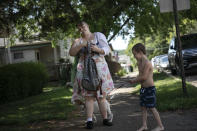 Brittany Cunningham 31, walks down the street with her nephew and his dog in Nelsonville, Ohio, on Friday, July 24, 2020. Brittany, a heroin addict, has been homeless for ten years. Her stories range from across a life steeped in addiction and badly chosen boyfriends to a deep love for music. (AP Photo/Wong Maye-E)