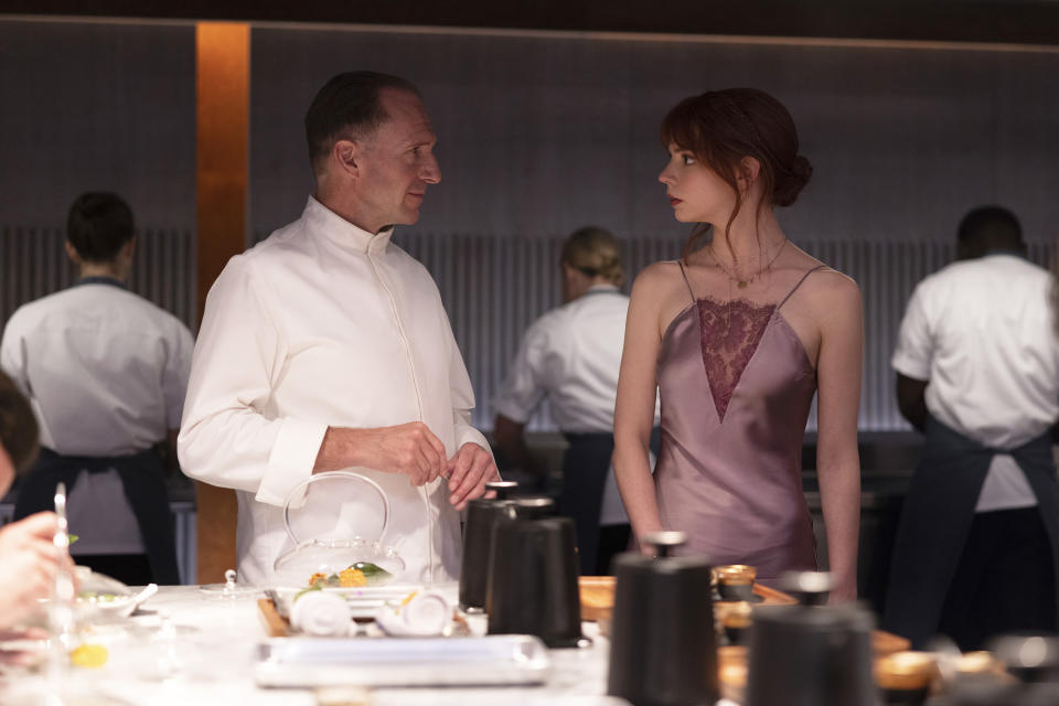 This image released by Searchlight Pictures shows Ralph Fiennes, left, and Anya Taylor-Joy in a scene from the film "The Menu." (Eric Zachanowich/Searchlight Pictures via AP)