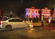 Several hundred demonstrators walk past the scene of a car crash during a protest against police brutality in Oakland, Calif., on Friday, April 16, 2021. (AP Photo/Ethan Swope)