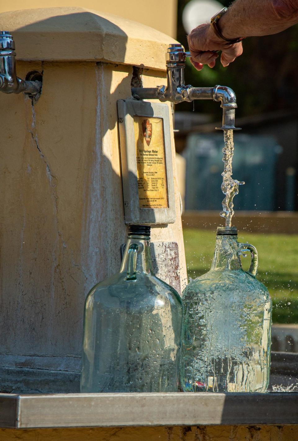 Visitors can collect fresh thermal spring water from jug fountains at Hot Springs National Park.