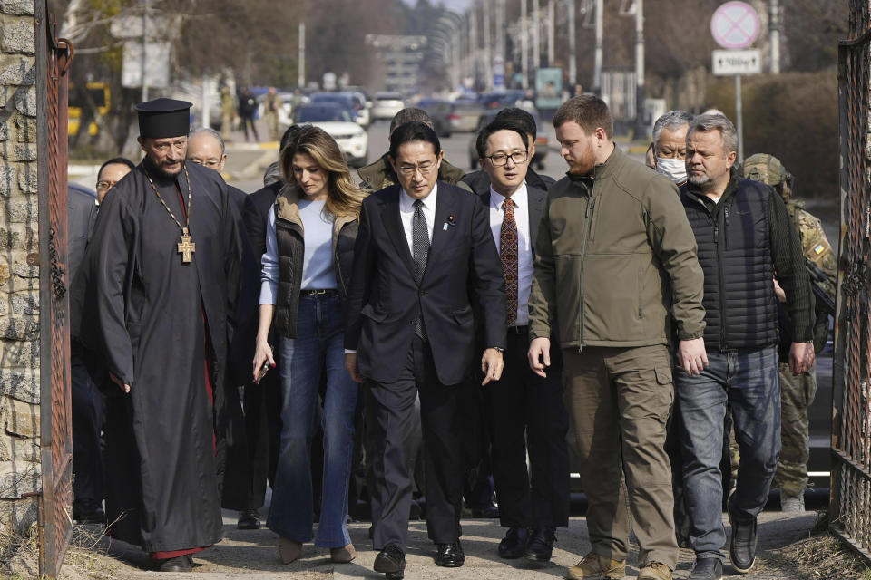 Japanese Prime Minister Fumio Kishida, center, arrives at a church in Bucha, a town outside Kyiv that became a symbol of Russian atrocities against civilians, in Ukraine, Tuesday, March 21, 2023.(Iori Sagisawa/Kyodo News via AP)