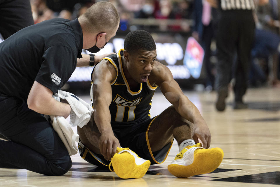 Virginia Commonwealth guard KeShawn Curry is shaken up after a play during the first half of an NCAA college basketball game against Davidson in Davidson, N.C., Wednesday, Jan. 26, 2022. (AP Photo/Jacob Kupferman)