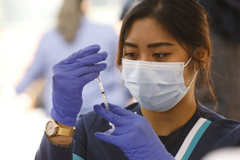 LOS ANGELES, CA - APRIL 20: Student registered nurse Camille Endicio prepares Pfizer Covid-19 vaccination syringes as at a new, walk-up mobile COVID-19 clinic launched today to provide the Pfizer COVID-19 vaccine to underserved communities in Los Angeles. The walk-up clinic was presented by Councilmember Mark Ridley-Thomas in partnership with CHA Hollywood Presbyterian Medical Center (CHA HPMC) and the Southern California Eye Institute (SCEI). The Mobile Vaccine Clinic at 1819 S. Western Avenue will be open every Tuesday starting April 20 through May 25 providing free vaccines to community members who are eligible per LA County Department of Public Health (LAC DPH) vaccine distribution guidelines as they partnered with Charles R. Drew University of Medicine and Science to provide student volunteers for on-site registration allowing for walk-up appointments for community members and further ensuring vaccine access in our hardest-hit communities. Los Angeles on Tuesday, April 20, 2021 in Los Angeles, CA. (Al Seib / Los Angeles Times).