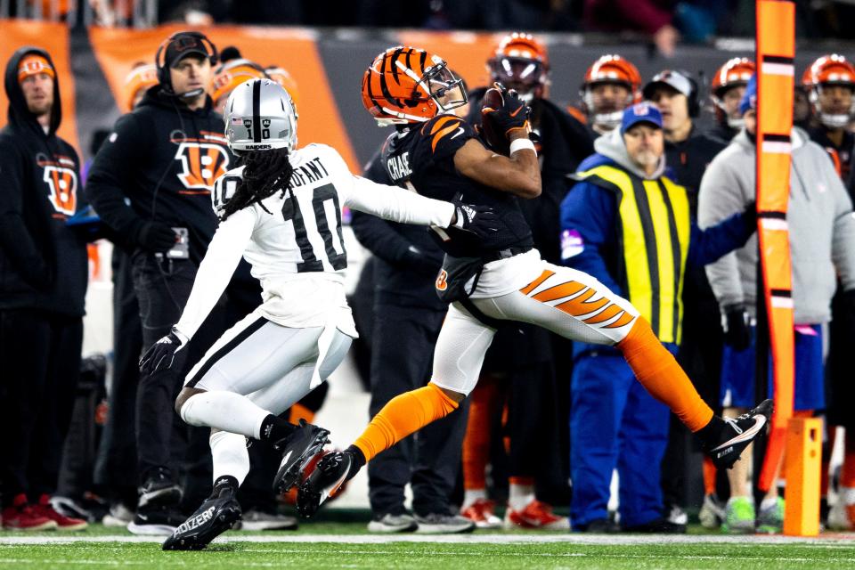 Cincinnati Bengals wide receiver Ja'Marr Chase (1) catchers a pass as Las Vegas Raiders cornerback Desmond Trufant (10) goes to tackle him in the second half the AFC wild card game on Saturday, Jan. 15, 2022, at Paul Brown Stadium in Cincinnati. Cincinnati Bengals defeated Las Vegas Raiders 26-19.