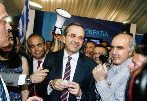 New Democracy party leader Antonis Samaras (C) smiles at supporters after his party came first in the national Greek's election, in central Athens. Greece's two main pro-bailout parties clinched enough votes to form a government in knife-edge elections on Sunday, as world powers pushed for a new cabinet as soon as possible to ease global fears