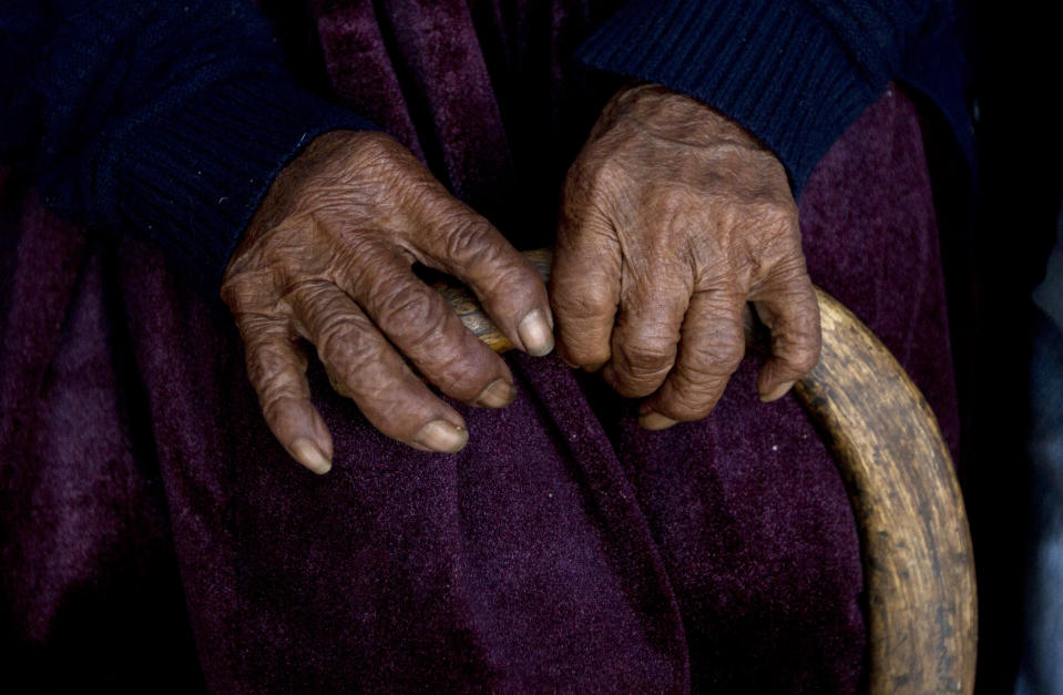 In this Aug. 23, 2018 photo, 117-year-old Julia Flores Colque holds onto her cane in Sacaba, Bolivia. The previously world's oldest person, a 117-year-old Japanese woman, died earlier this year. Her passing apparently left Flores Colque as the world's oldest living person. (AP Photo/Juan Karita)